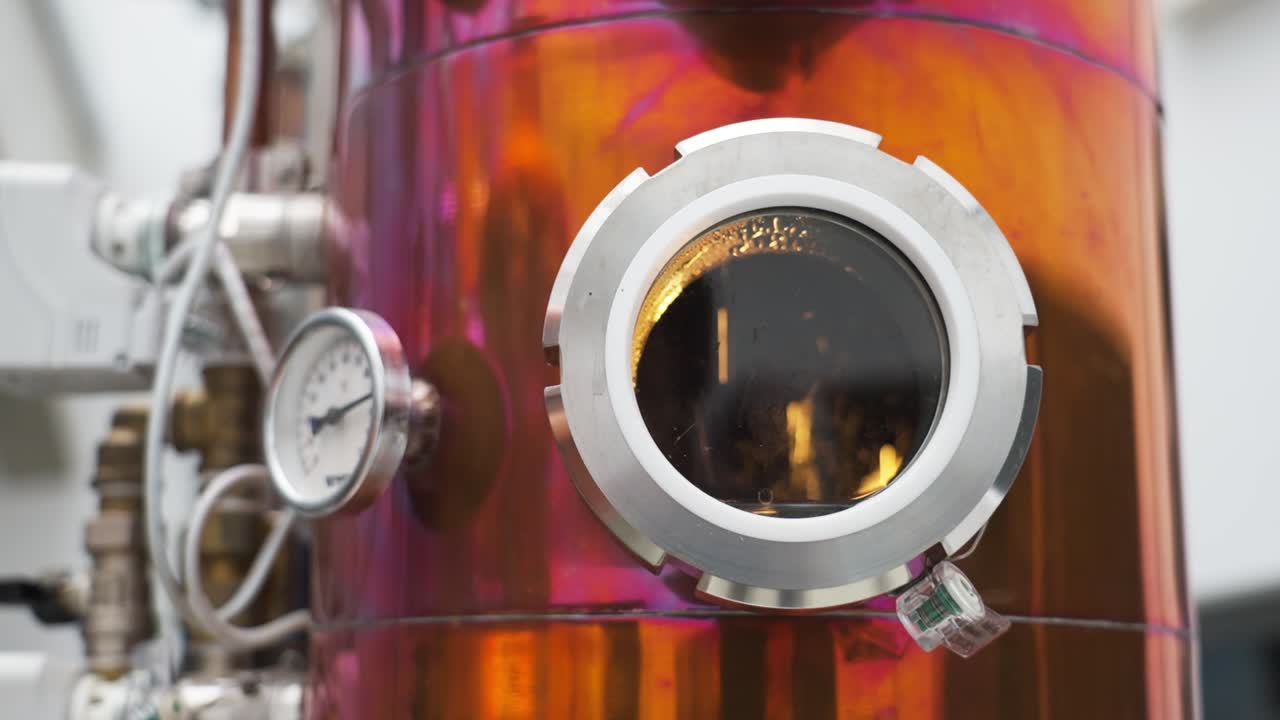 Copper boiler with a view window showing distillation in process