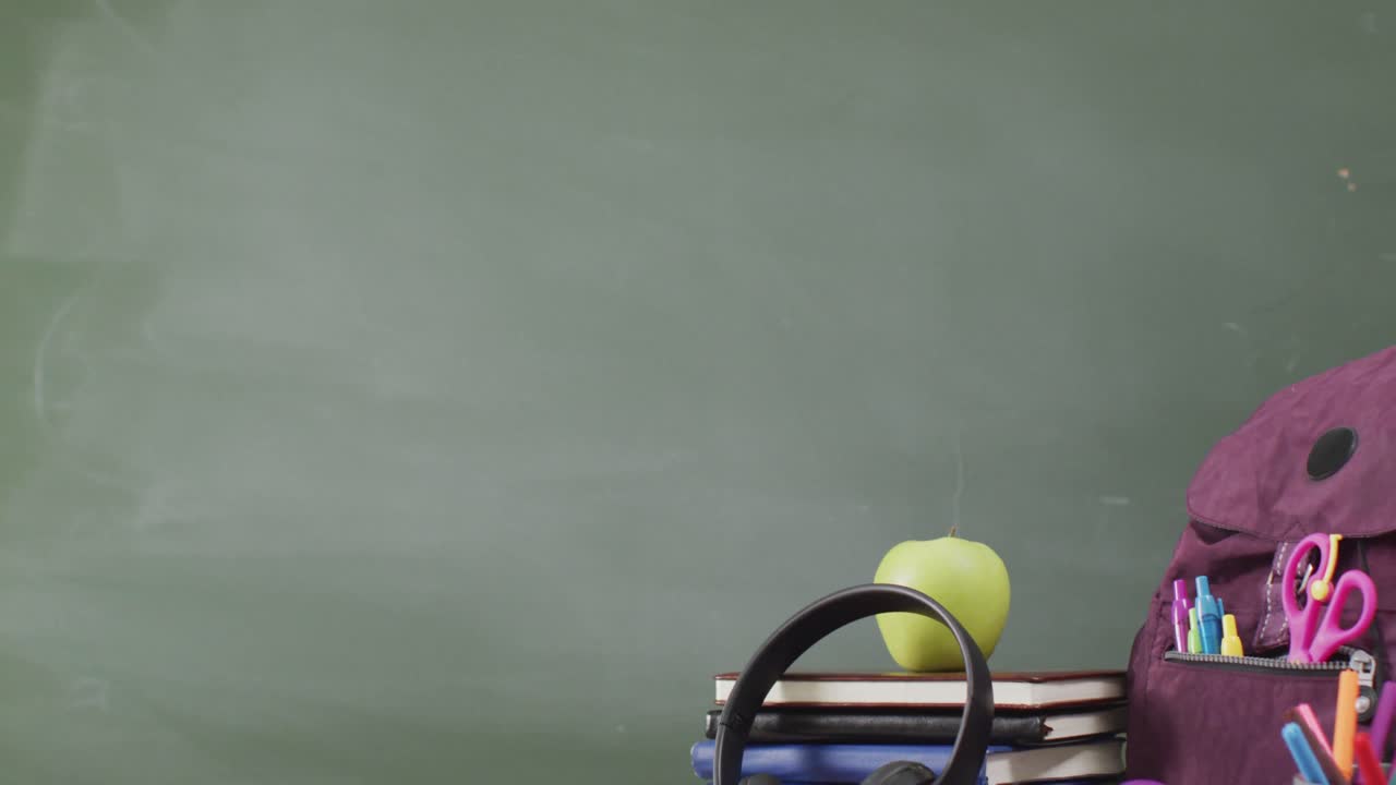 블랙보드 위 의 나무 테이블 에 있는 학교 용품 과 책 들 의 비디오