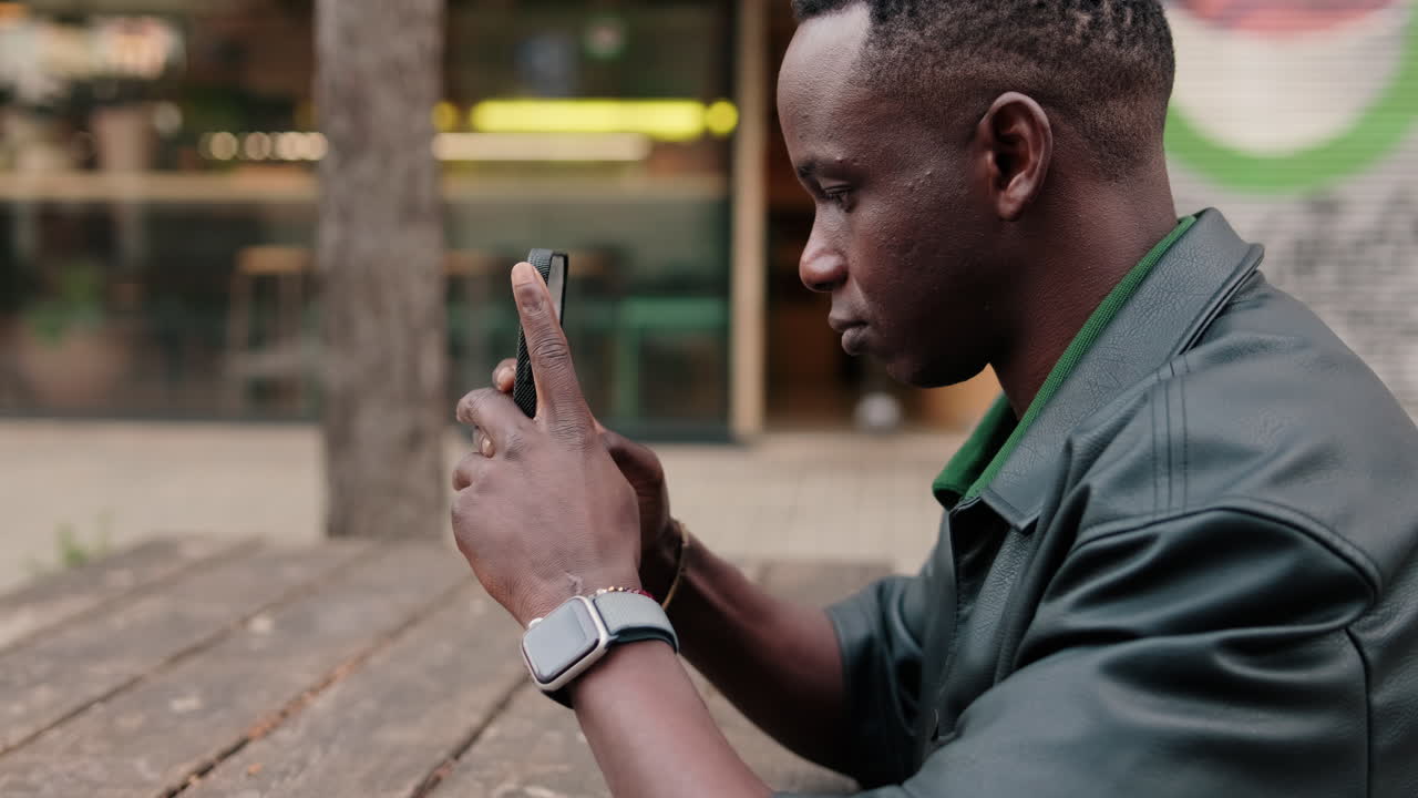 Young African Man Using Smartphone Outdoors