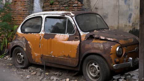 old car, fiat 500, bangkok, thailand burned trashed abandoned next to brickwork wall