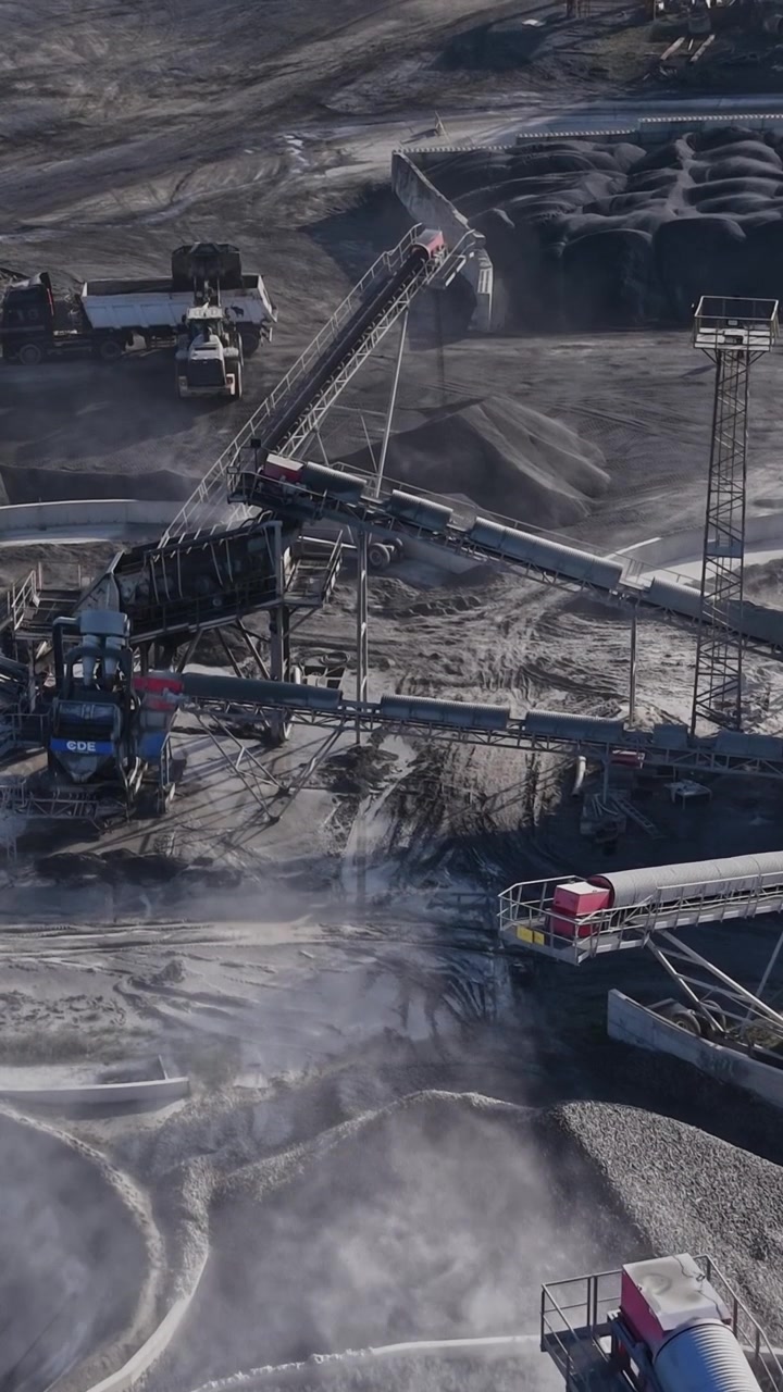 Heavy machinery and conveyor belts at a busy quarry site