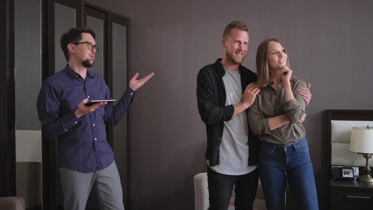 Coppia che guarda una nuova proprietà con un agente immobiliare