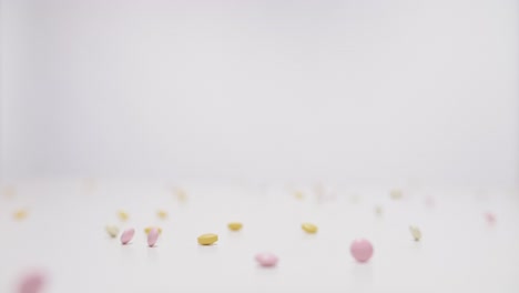 different kinds pills falling on white background in slow motion