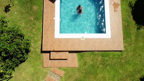 overhead shot of mother and son enjoying warm water in stunning pool design