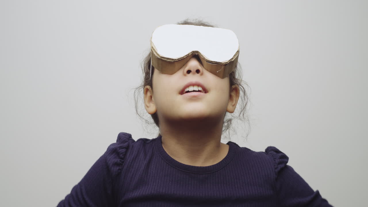 Girl Imagines Being in Virtual Reality While Wearing Homemade Cardboard VR Goggles