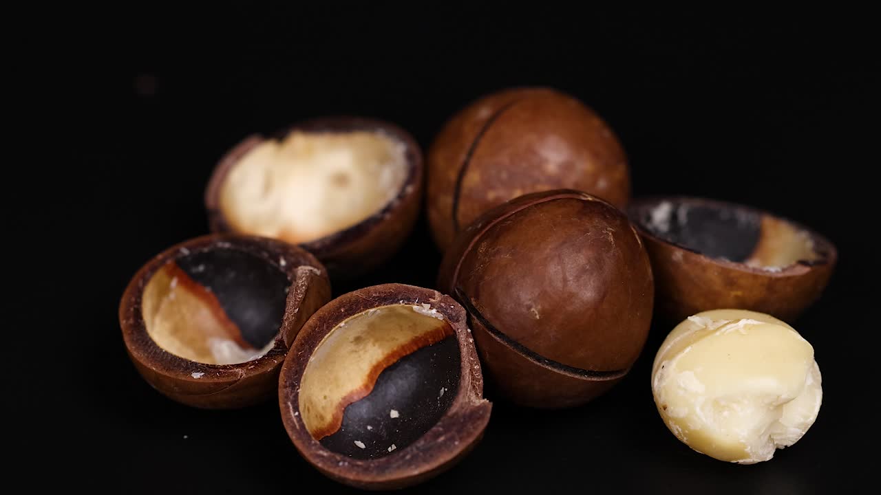 Noci di macadamia disposte su uno sfondo scuro