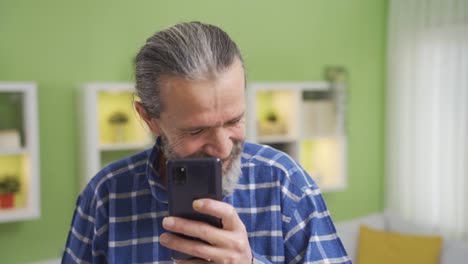 Old-man-using-smartphone-laughing-at-funny-videos-or-messages.