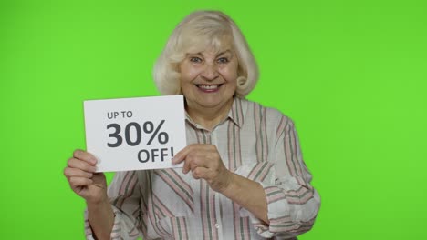 Senior-grandmother-showing-Up-To-30-percent-Off-inscription-signs,-rejoicing-discounts.-Black-Friday