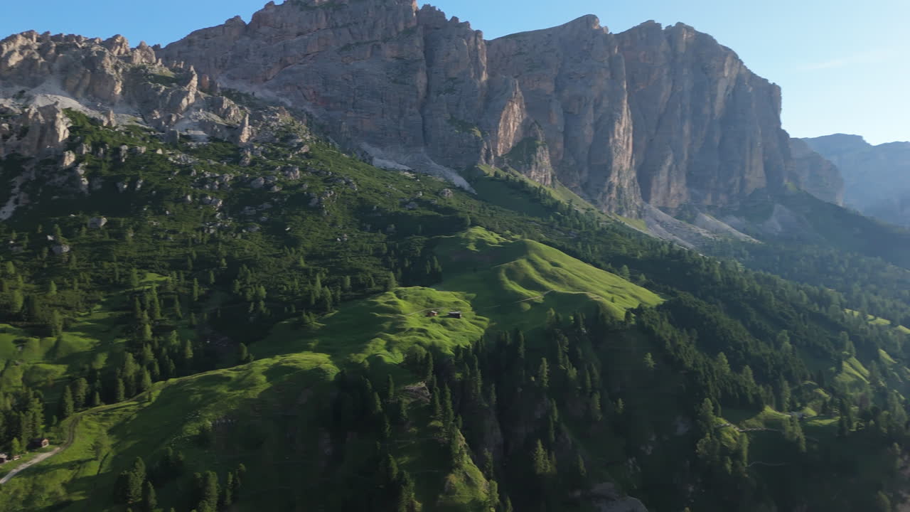 Stunning panorama of the Dolomite Alps at sunrise with deep shadows and tiny houses on the slopes. Breathtaking mountain scenery