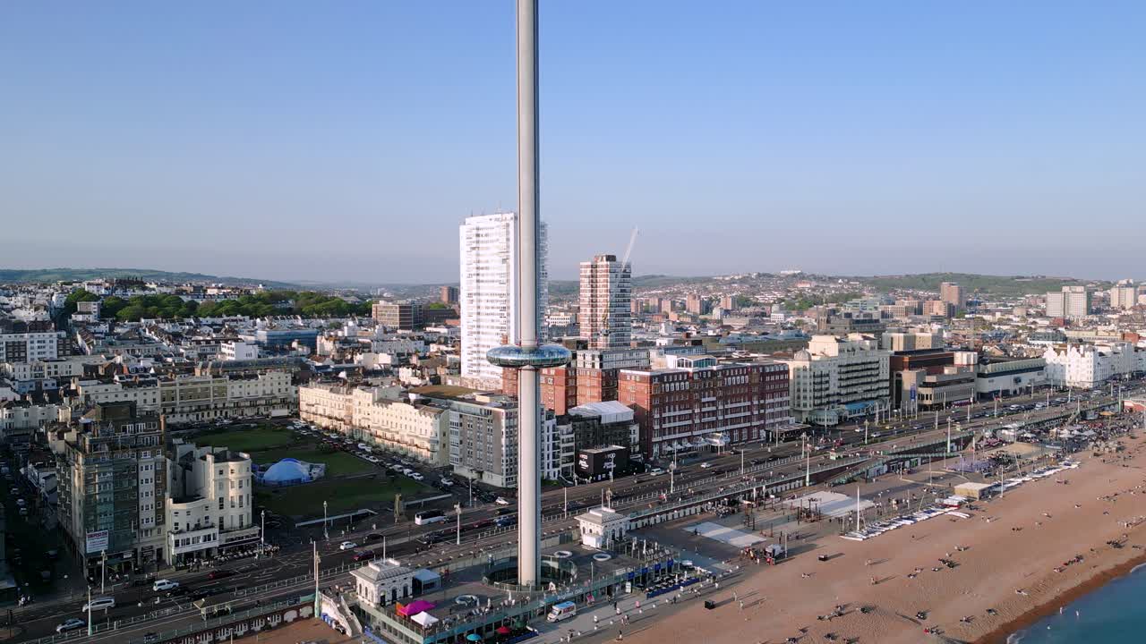 Zoom arrière aérien de la tour Brighton i360 avec le paysage urbain et le trafic du front de mer à Brighton, Angleterre.