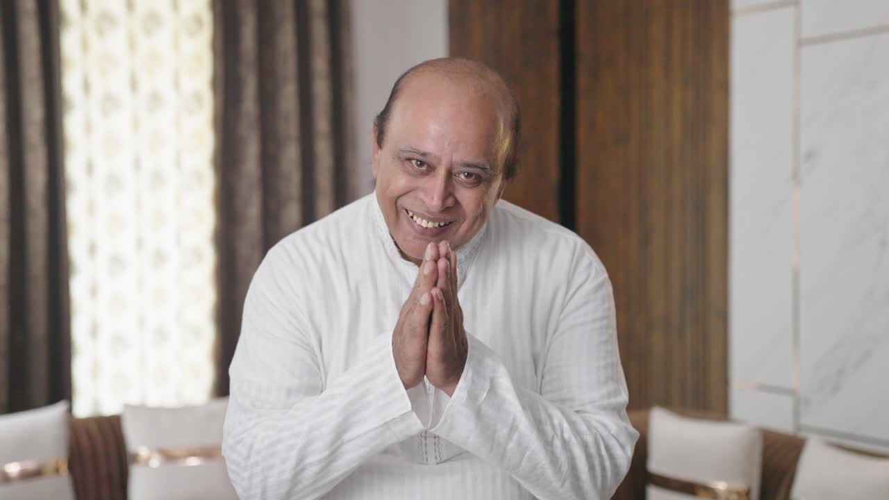 Indian old man greeting and doing Namaste as a sign of respect