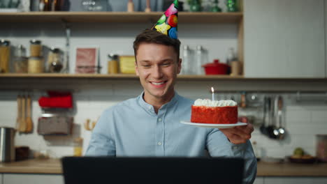 man enjoy virtual birthday holding cake blowing candle closeup. guy celebrating.