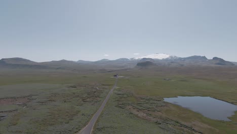view from above, rural road, glacier and ingjaldshóll church in distance, iceland