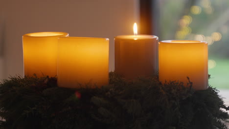 tres velas brillantes en una corona de hoja perenne, un ambiente festivo