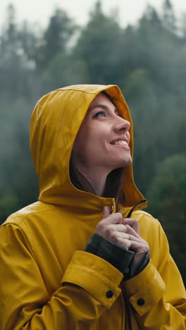 woman in yellow raincoat enjoying the rain