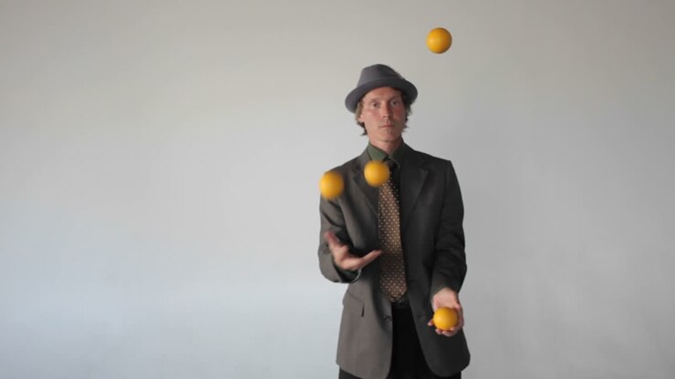 A man is juggling four balls