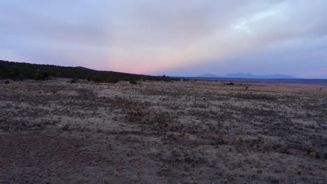 Sunset-behind-mountain-with-twilight-color-sky-and-clouds-on-a-western-landscape-in-Norwood,-Colorado