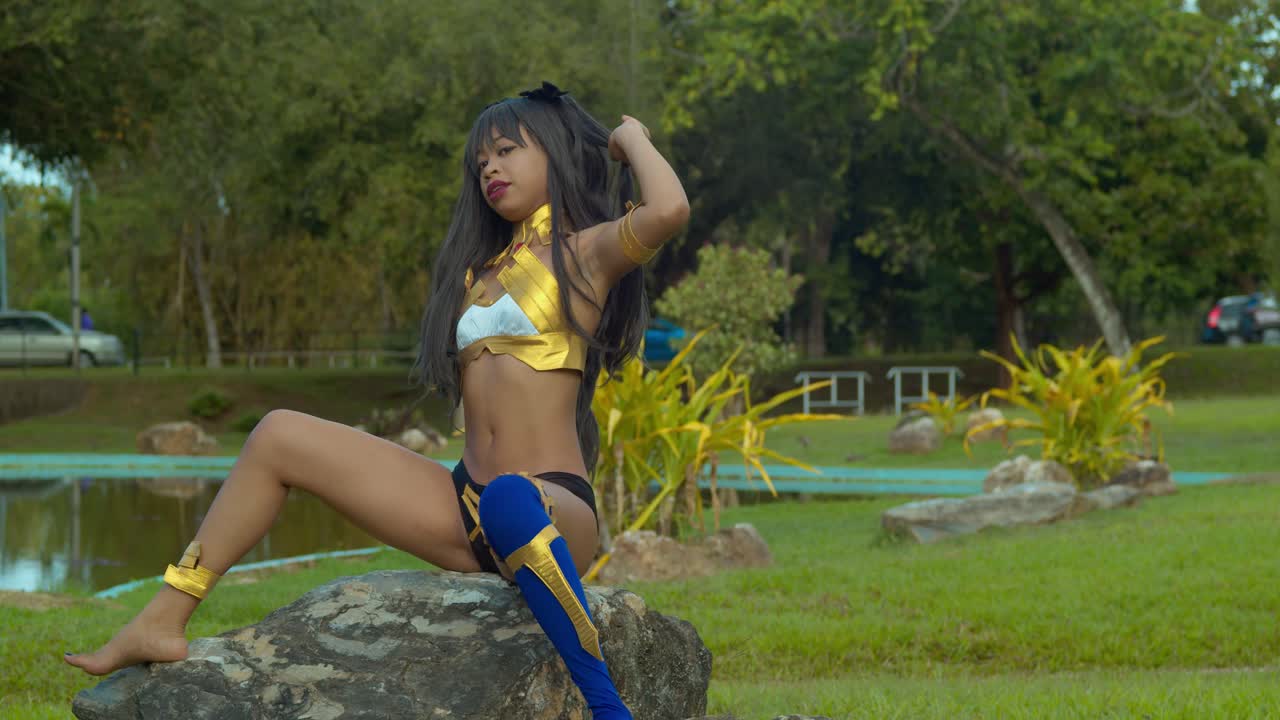 fate grand order 의상의 섹시한 이슈타르를 입고 바위에 앉아 있는 어린 소녀