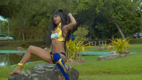 una joven se sienta en una roca con un disfraz sexy de ishtar del destino de la gran orden