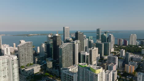 Ascending-panoramic-footage-of-coastal-borough-with-modern-high-rise-apartment-buildings.-Miami,-USA