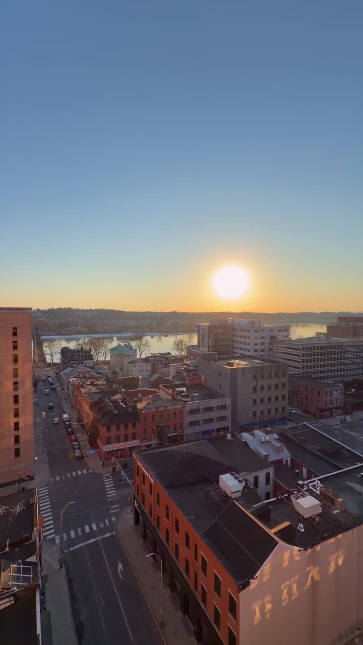 Um belo e sereno pôr do sol em hora dourada capturado com foco suave sobre uma paisagem urbana distante.