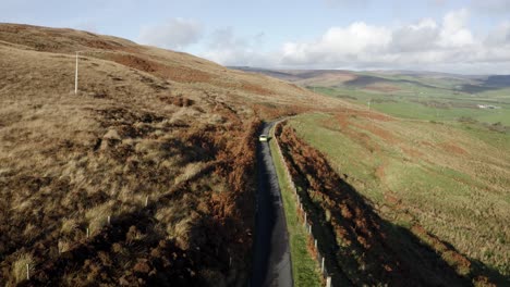 vista de un coche que pasa por una carretera en la campiña escocesa en otoño, un lugar llamado mull of kintyre