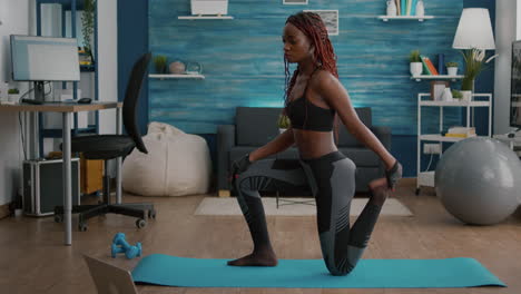 fitness woman with black skin practicing fitness workout in living room