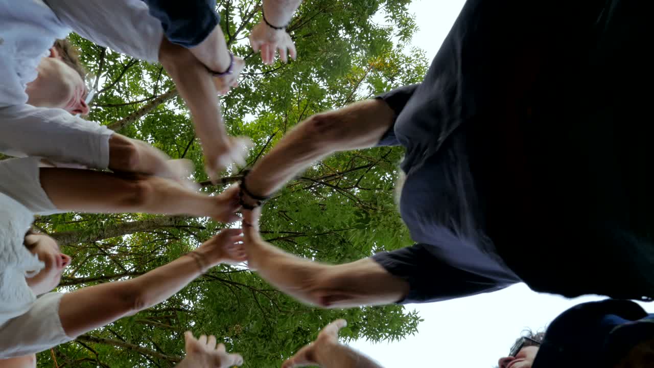 A mixed generational group of people high five one another