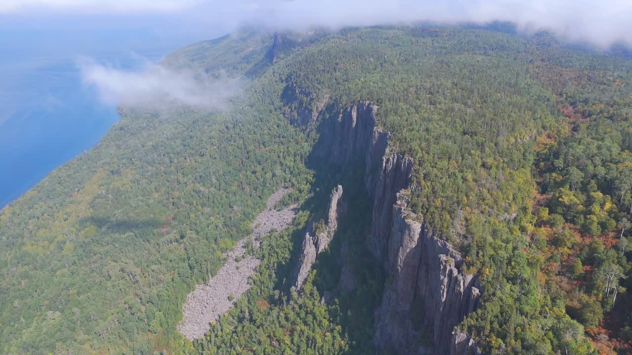 A stunning view of the towering cliffs at Sleeping Giant, Ontario, surrounded by dense green forest overlooking the vast expanse of Lake Superior