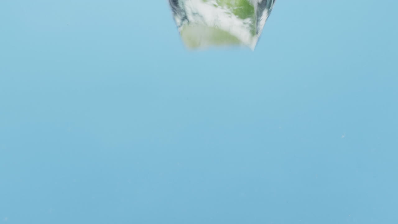 블루 배경에 복사 공간과 함께 물에 떨어지는 열매와 과일의 비디오