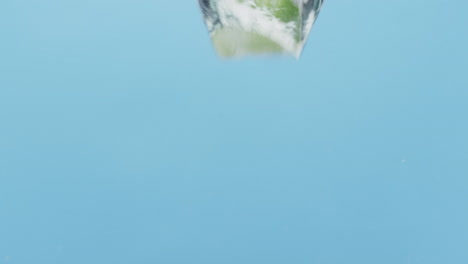 video de bayas y frutas cayendo en el agua con espacio de copia en fondo azul
