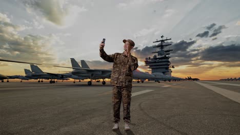 full body of asian man soldier using smartphone taking picture while standing on aircraft carrier
