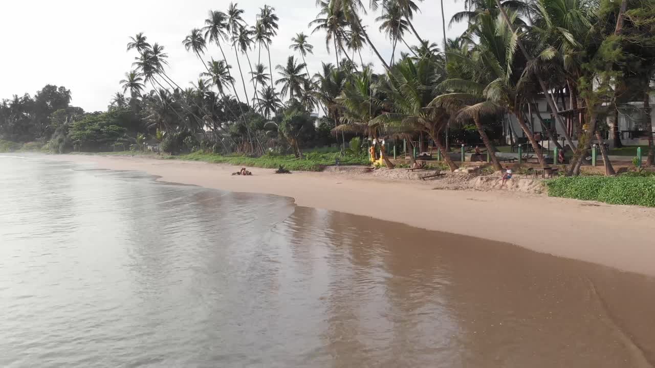 Drone che vola basso sopra la riva sabbiosa della spiaggia di Hiriketiya in Sri Lanka
