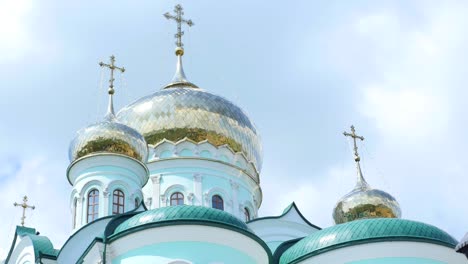 cruces ortodoxas orientales en cúpulas de oro contra el cielo nublado azul