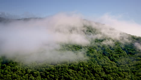 cinematic overhead view drifting into cloudy mountain terrain