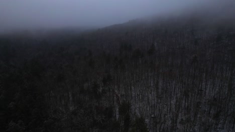 aerial drone video footage of nightfall in the snowy, foggy, magical appalachian mountains during winter, in the catskill mountains sub-range