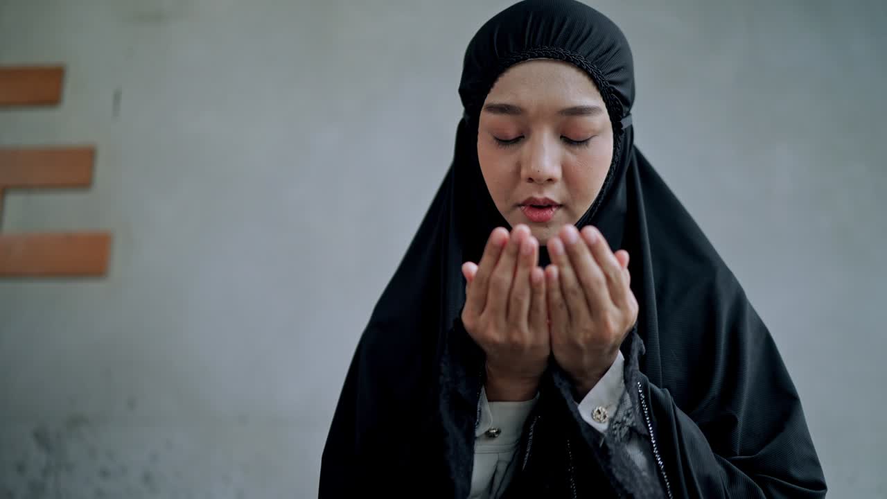 집에서 기도하는 아시아 젊은 무슬림 여성