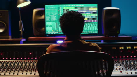 african american sound producer editing tracks on audio software and console