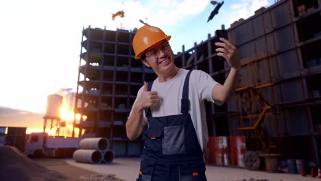 un trabajador asiático usando un teléfono inteligente tomando fotos en un sitio de construcción