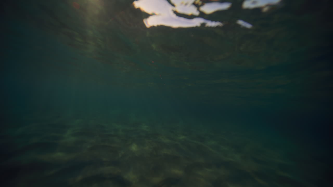 los brillantes rayos del sol se encienden bajo el agua en la superficie del océano