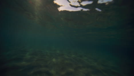 Sparkling-sun-rays-flare-up-underwater-on-ocean-surface