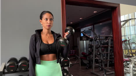 slow motion close-up shot of a determined female working out using dumbells