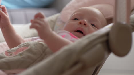 Calm-baby-girl-in-bouncy-seat-at-home