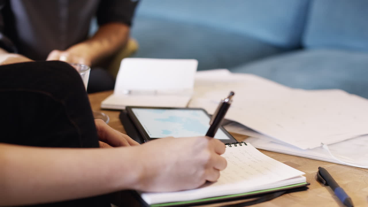 디지털 태블릿 컴퓨터를 사용하여 카페에서 회의하는 비즈니스 여성