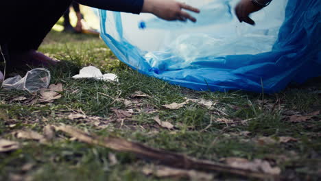 diverse volunteers collecting trash and storing in the garbage bag