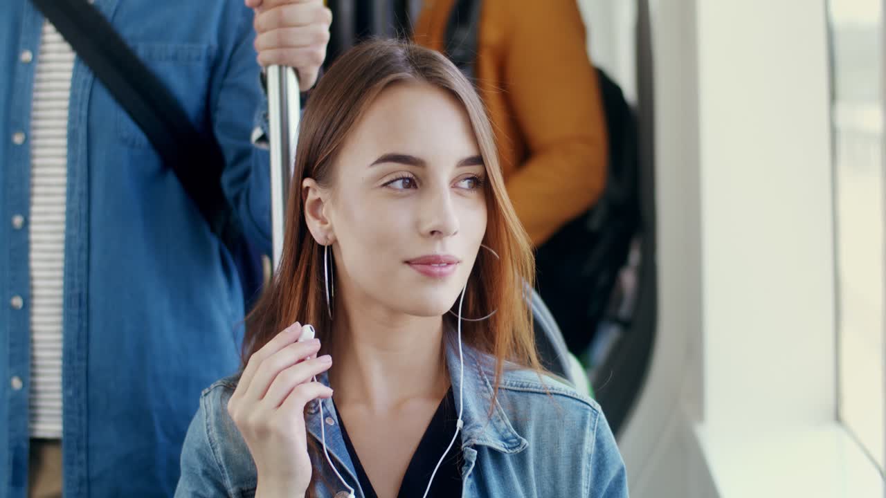 hermosa corredora sonriente apoyada contra una pared y hablando con su novio parado frente a ella mientras se toman un descanso durante una sesión de entrenamiento en la ciudad
