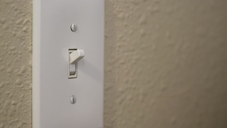 la mano del hombre apaga y enciende el interruptor de la luz