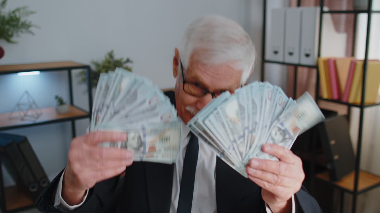 Forretningsmann regnskapsfører feirer forretningssuksess og danser med en stabel av penger i dollar