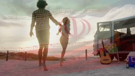 animation of waving flag of iran over couple having fun on the beach