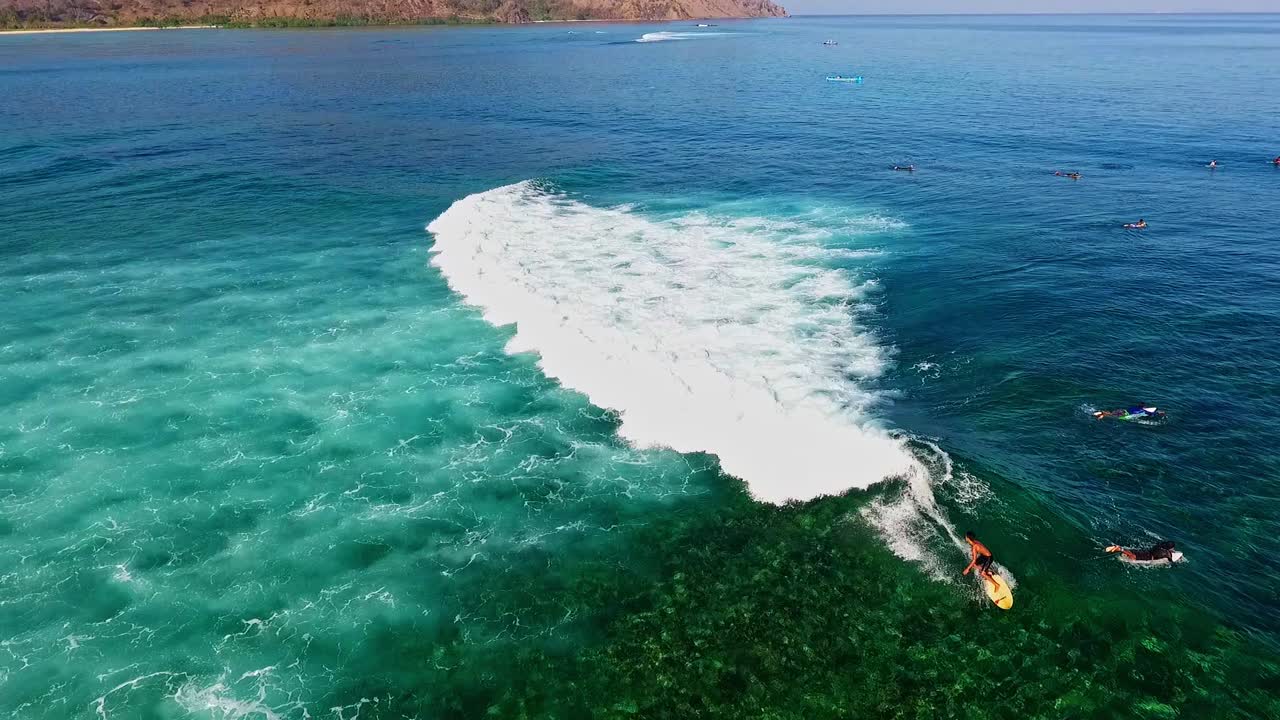 surfistas tallando olas en la playa de jelenga indonesia